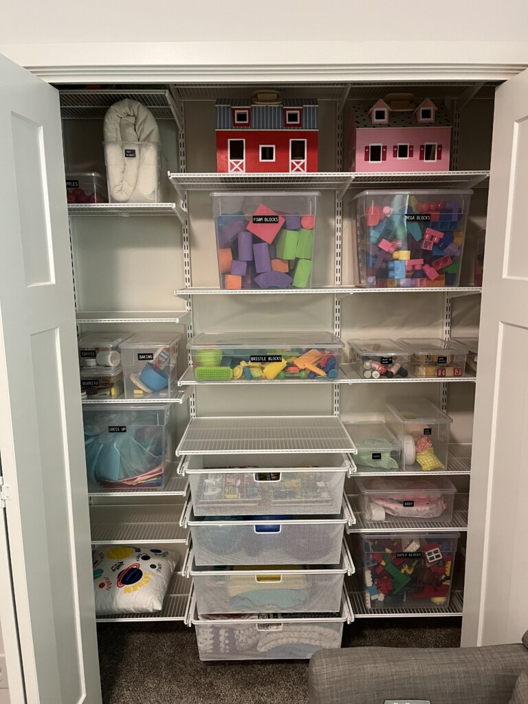a closet that is showing toys in an organized way - clear bins with black labels with white font, professional organizer in omaha